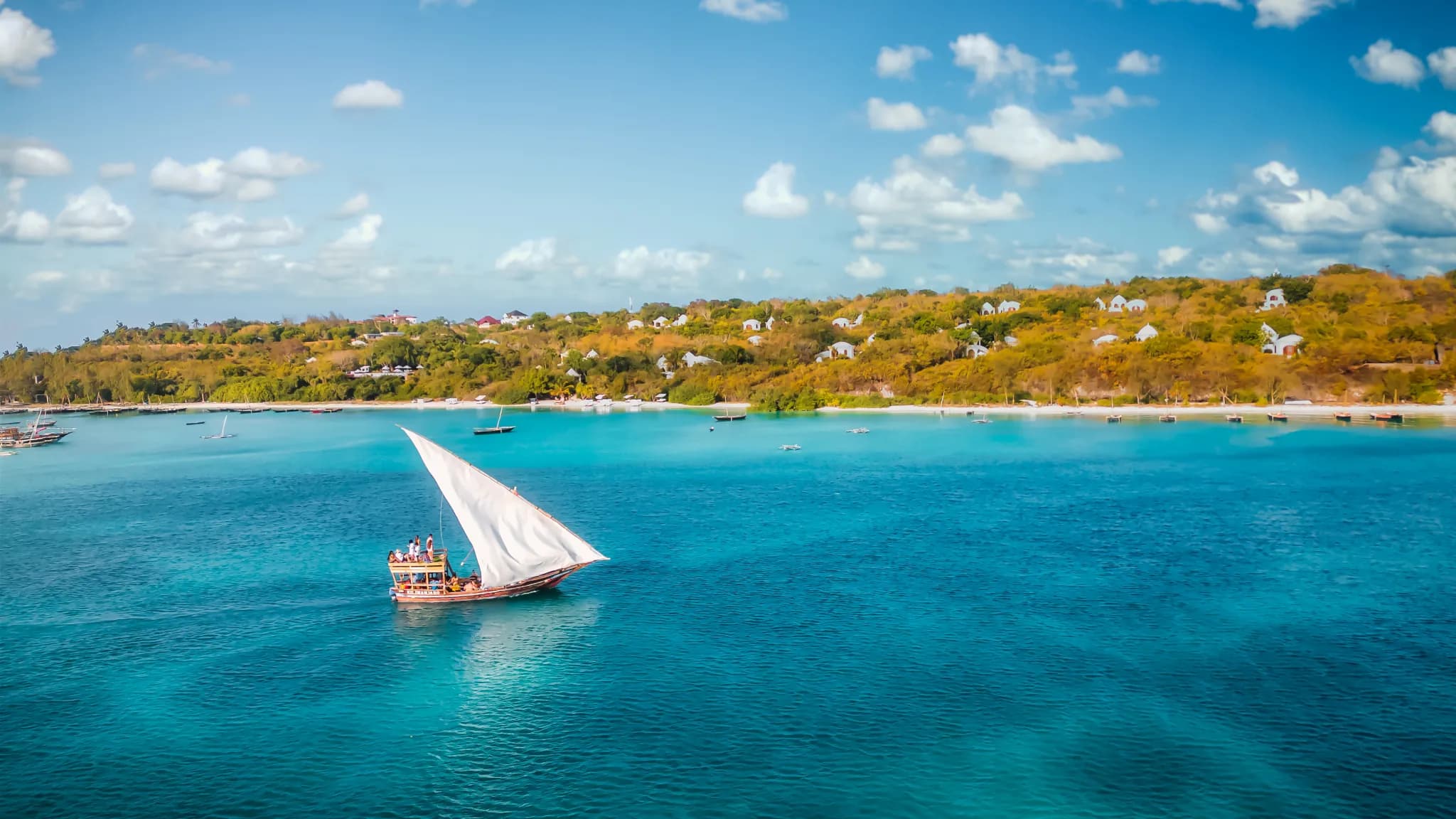A traditional dhow crossing the turquoise bay in front of Kilindi Zanzibar — Photo: Elewana Collection