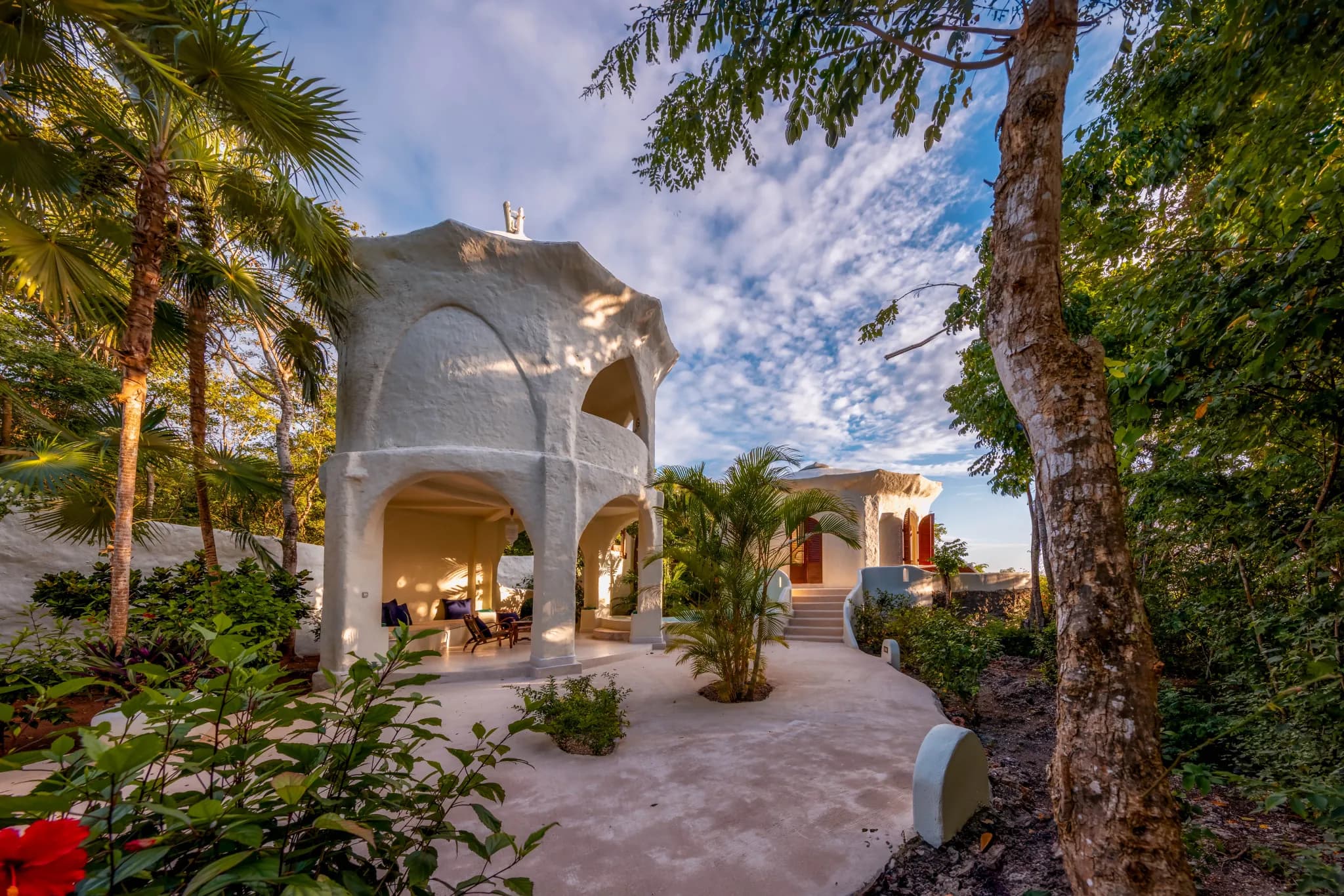 A white domed villa at Kilindi Zanzibar, set among tropical gardens above the beach — Photo: Elewana Collection