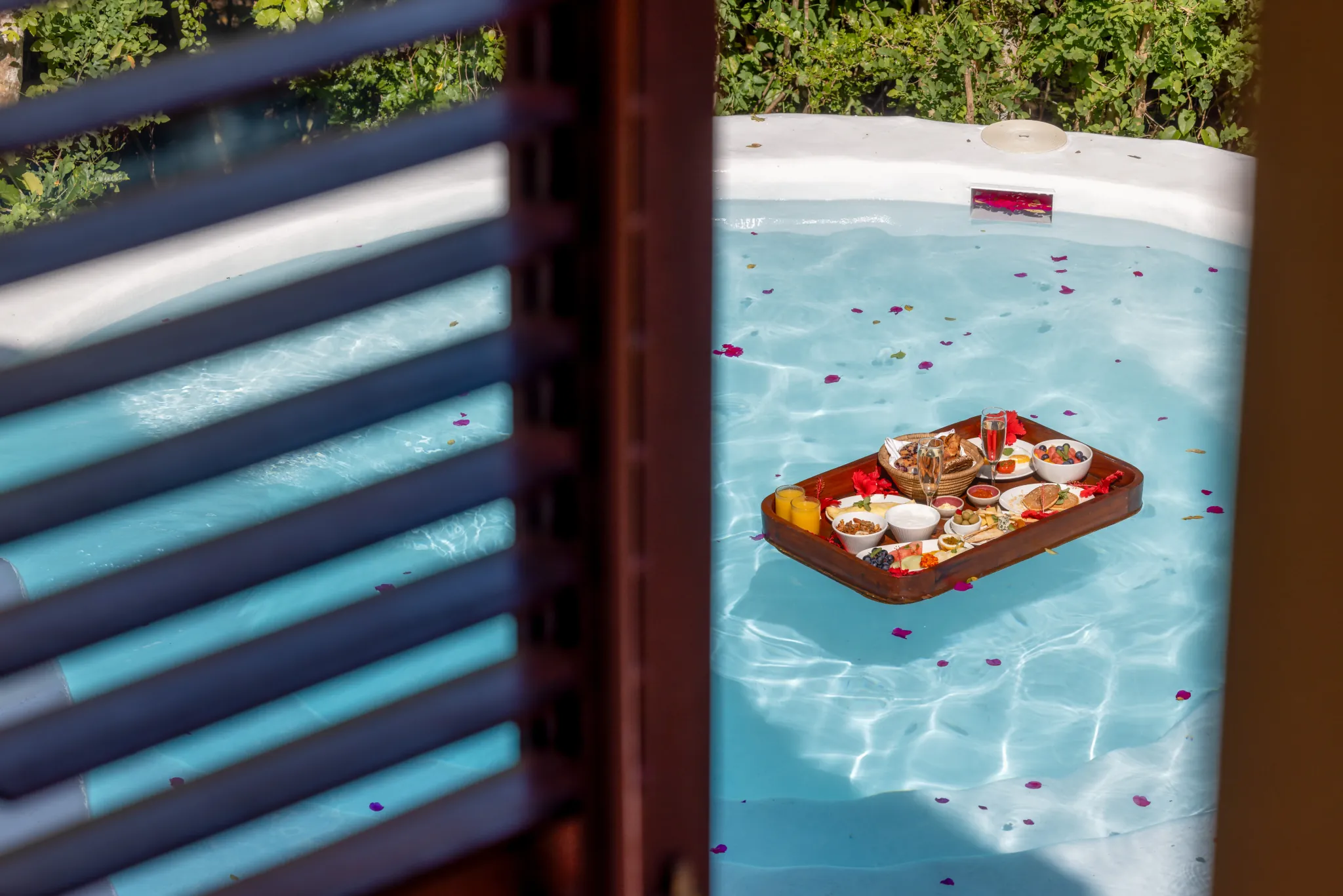 A floating breakfast tray drifting on a private plunge pool at Kilindi Zanzibar — Photo: Elewana Collection