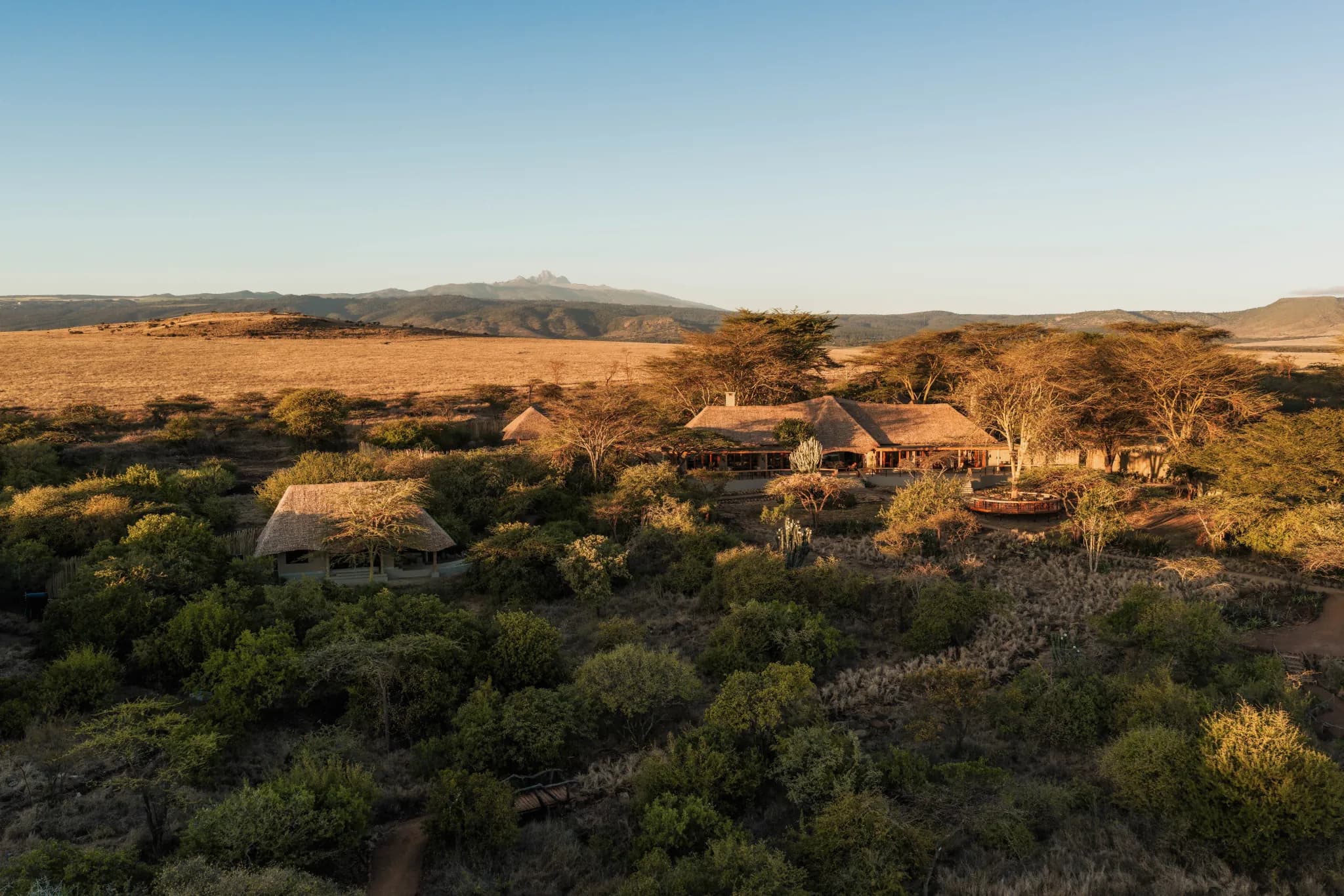 Lewa Safari Camp at sunrise, set among the conservancy bush — Photo: Elewana Collection
