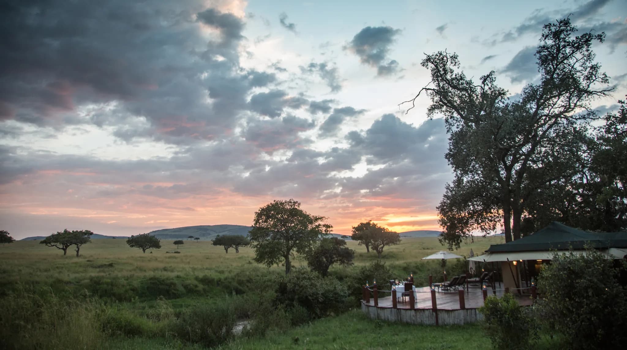 Little Sand River lit against the dusk, its deck set above the river — Photo: Elewana Collection / Silverless