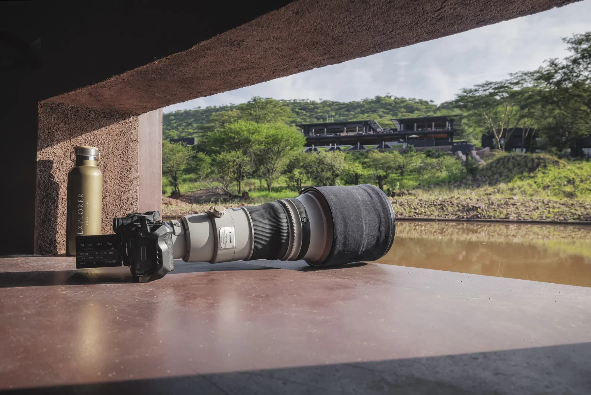 The semi-submerged photographic hide at Serengeti Explorer, a long lens trained across the waterhole toward the lodge — Photo: Elewana Collection