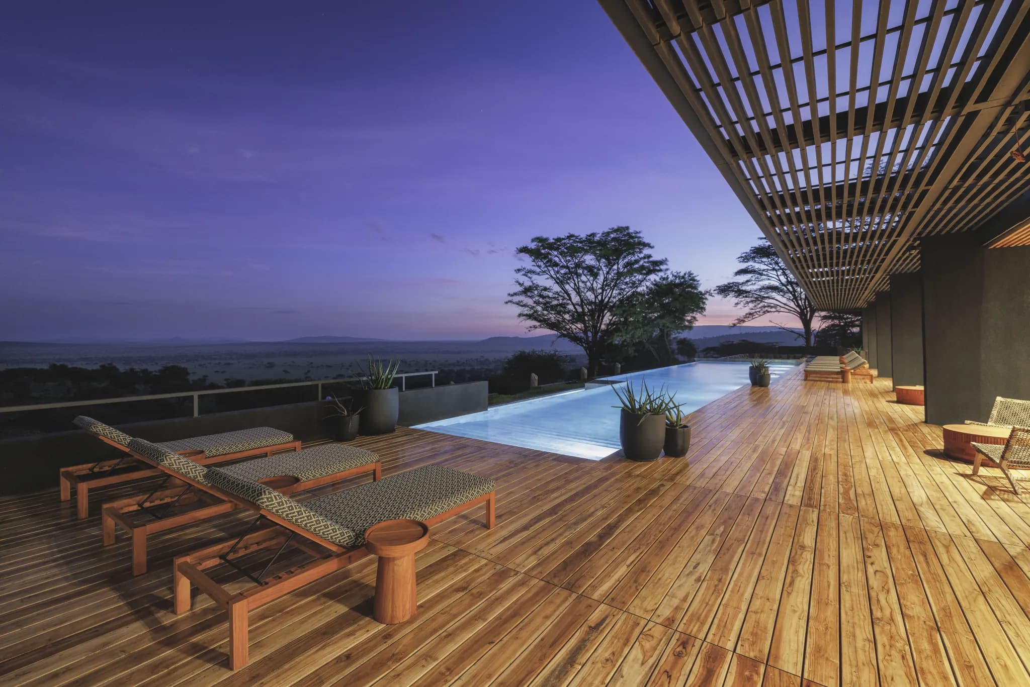 The infinity pool deck at Serengeti Explorer at dusk, looking out over the plains — Photo: Elewana Collection