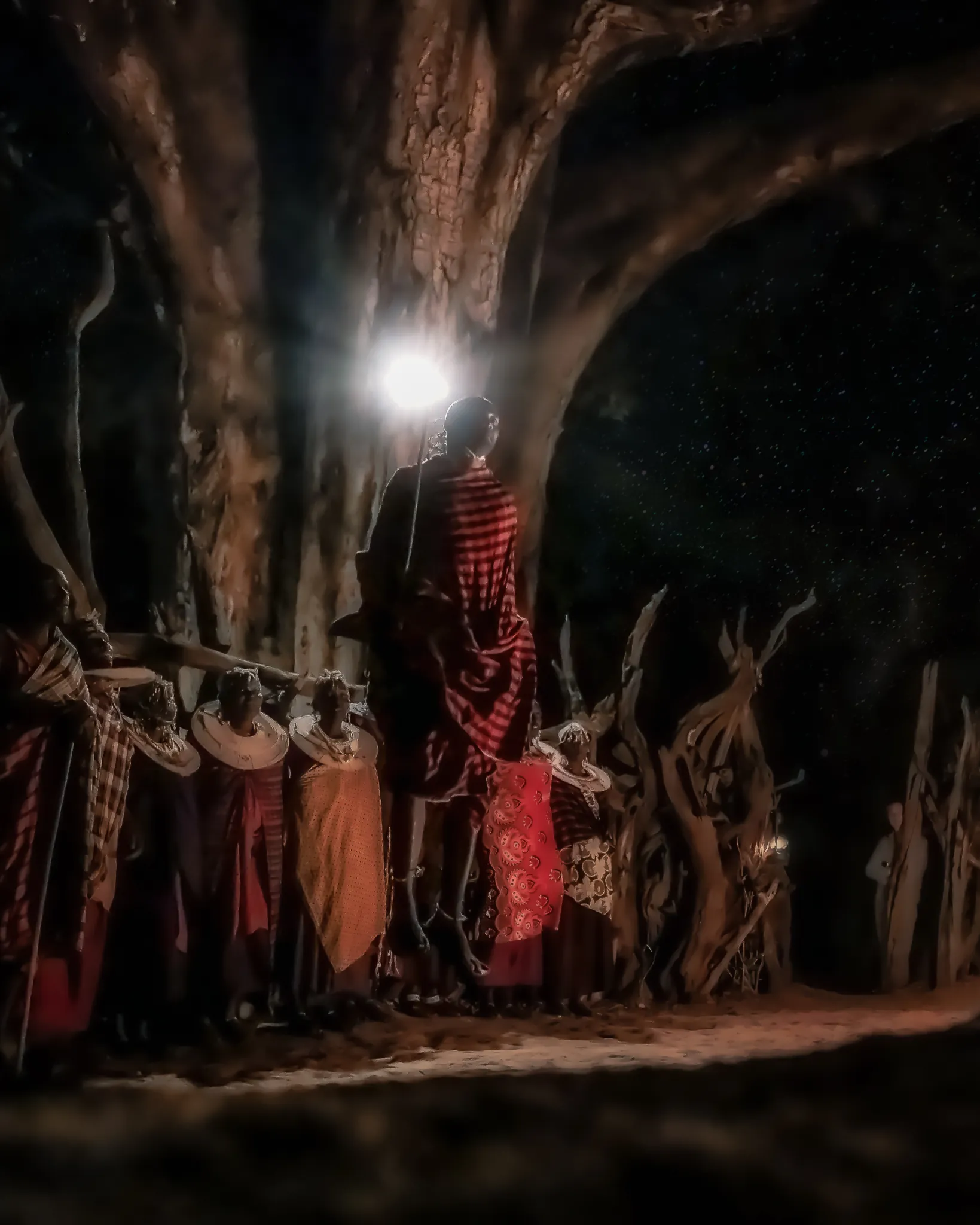 Maasai dancers gathered beneath a baobab after dark near Tarangire Treetops — Photo: Elewana Collection