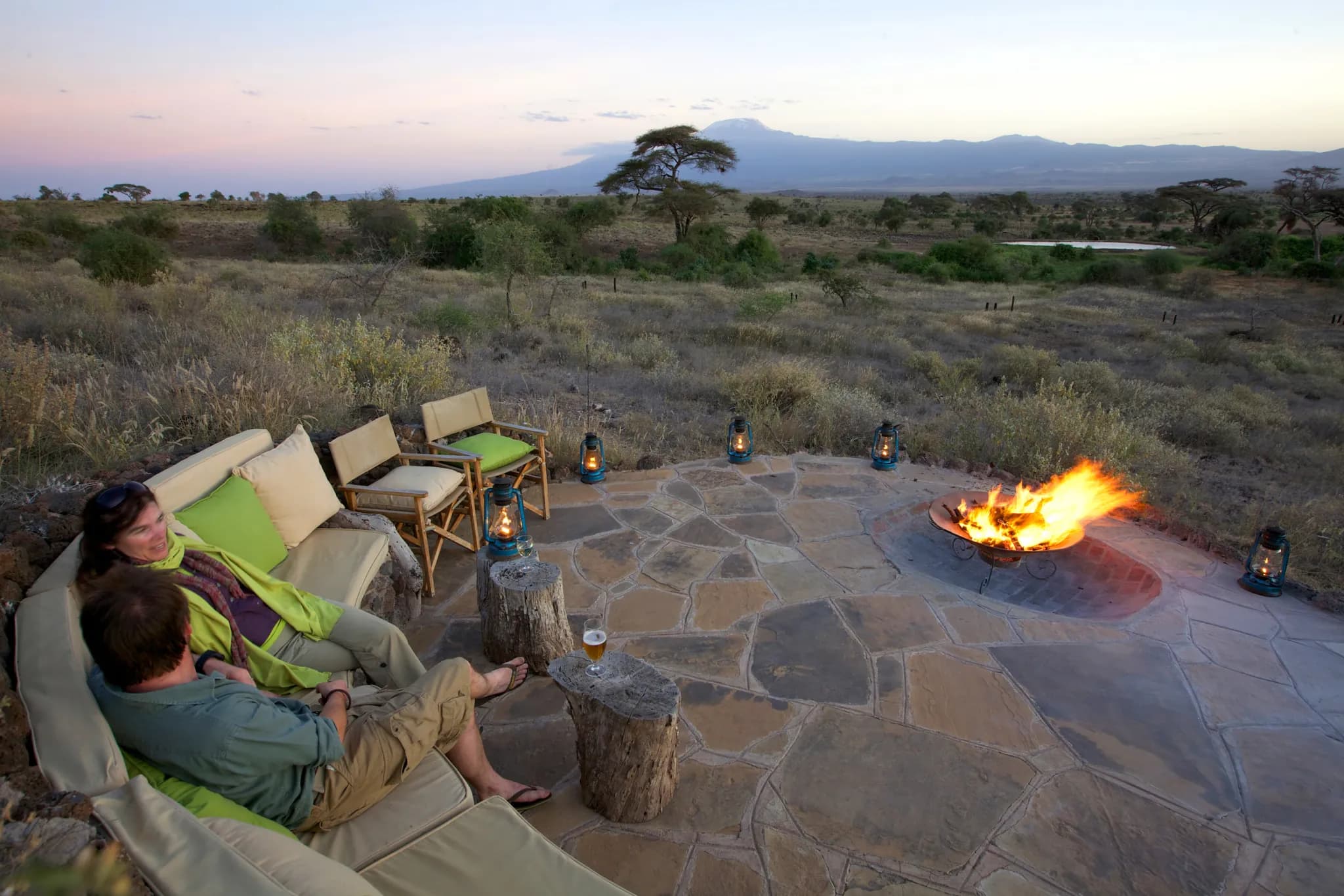 Sundowners by the camp fire on Liimbarishi Hill, Mount Kilimanjaro beyond — Photo: Elewana Collection / Silverless